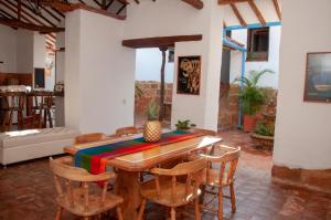 uma sala de jantar com uma mesa de madeira e cadeiras em La Juanita Hostel Barichara em Barichara