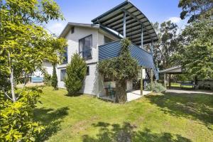 una casa blanca con techo de gambrel en Phillip Island Time - Large home with self-contained apartment sleeps 11 en Cowes