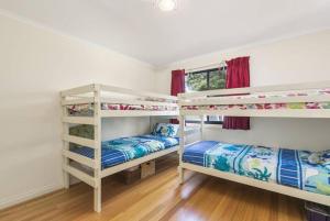 a room with two bunk beds and a window at Phillip Island Time - Large home with self-contained apartment sleeps 11 in Cowes