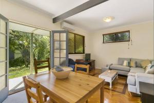 Phillip Island Time - Large home with self-contained apartment sleeps 11 في كاوز: غرفة معيشة مع طاولة وأريكة