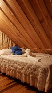 Cama en habitación con techo de madera en Cabaña Doña dacia en Alaska