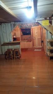 Habitación con armarios de madera, mesa y suelo de madera. en Cabaña Doña dacia en Alaska
