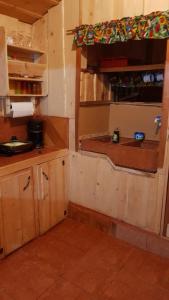 a small kitchen with wooden cabinets and a window at Cabaña Doña dacia in Alaska