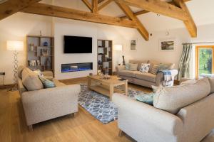 a living room with two couches and a tv at Butterwell Barn in Hemborough Post