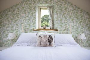 a bedroom with a bed with a dog pillow on it at Winsbury Cottage in West Hauxwell