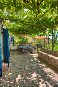 a patio with a table and chairs under a tree at Holiday Home Neda in Sveti Stefan