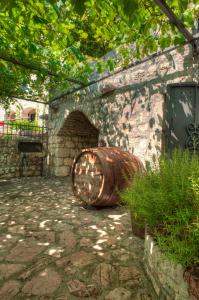 a large barrel sitting next to a stone wall at Holiday Home Neda in Sveti Stefan