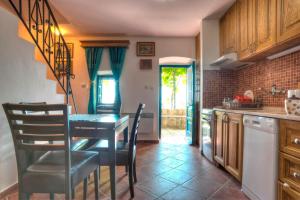 a kitchen with a table and chairs in a room at Village house Neda in Sveti Stefan