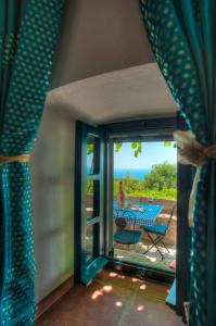 a room with a door open to a patio with a table at Village house Neda in Sveti Stefan