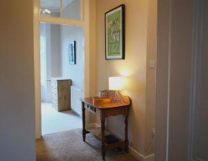 a hallway with a table with a lamp on it at Forth View Apartment in Stirling