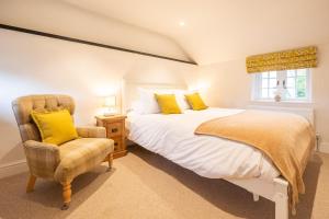 a bedroom with a bed and a chair at 1 Chantry Cottage in Tunstall