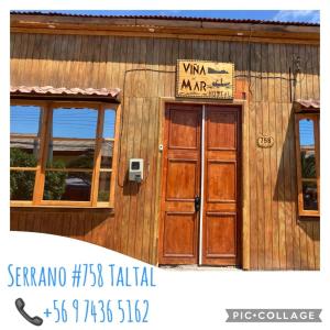 budynek z drewnianymi drzwiami z napisem w obiekcie Hostal Viña Del Mar w mieście Taltal