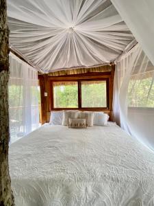 a bedroom with a large bed in a tent at Nuscaa Boutique Tree House & Spa in Puerto Morelos