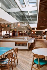 a restaurant with tables and chairs and a large skylight at Mercure Melbourne Doncaster in Doncaster