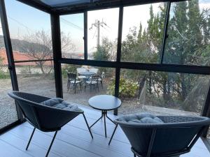 a room with two chairs and a table in front of a window at Tiz wan 洲本 in Sumoto