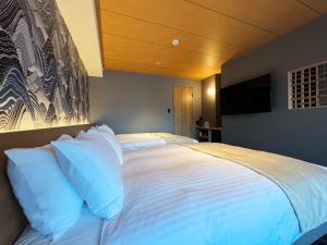 a large bed with white pillows in a bedroom at Rinn Gion Shirakawa in Kyoto