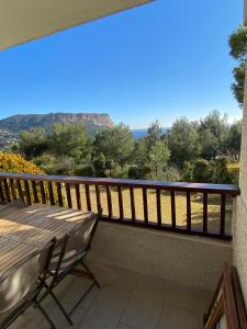a balcony with a table and a view of the mountains at La Piscine K6&You in Cassis