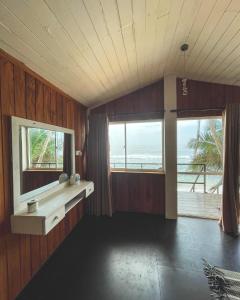a room with wooden walls and windows with a view of the ocean at Why Not Guest house in Hikkaduwa