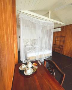a table with a tea set on it with a window at Why Not Guest house in Hikkaduwa