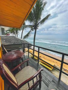 a balcony with chairs and a view of the ocean at Why Not Guest house in Hikkaduwa