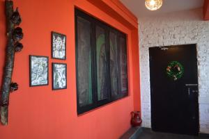 a hallway with an orange wall with pictures on it at Zemu Gangtok in Gangtok