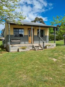 a small house with a porch and a yard at Mansfield Holiday Park in Mansfield