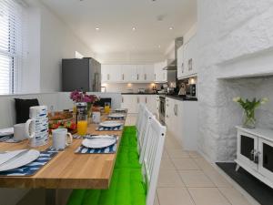Una cocina con una mesa de madera con un camino de mesa verde. en 6 Albany Terrace, en St Ives