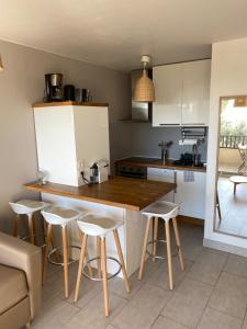 a kitchen with a counter and some stools in it at La Piscine K6&You in Cassis