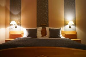 een slaapkamer met een groot bed met 2 lampen bij Gasthaus Heiko Sieb in Wischhafen