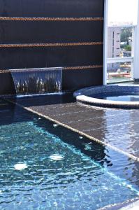 a swimming pool with blue water in a building at Hotel Real Alameda de Queretaro in Querétaro