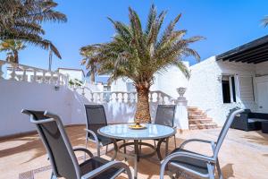 une table et des chaises sur une terrasse avec un palmier dans l'établissement Beautiful Villa Duque With Pool Poris Tenerife South, à Poris de Abona
