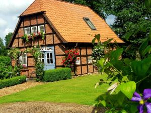 a house with an orange roof and a yard at Gästehaus am Kattensteert in Borchel