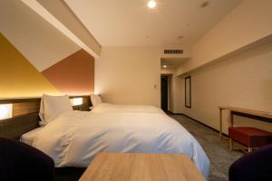 a hotel room with a bed and a table at Hotel Kanazawa in Kanazawa