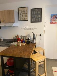 Una cocina con una mesa de madera y dos taburetes. en joli petit nid douillet en centre ville, en La Rochelle 2 fotos más