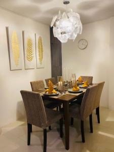 uma mesa de jantar com cadeiras e um lustre em UNWND Residences Dumaguete em Dumaguete