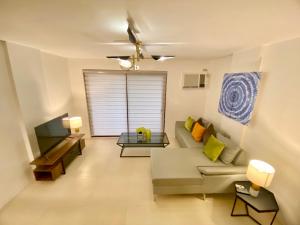 uma sala de estar com um sofá e uma televisão em UNWND Residences Dumaguete em Dumaguete