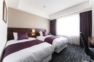 a hotel room with two beds and a window at ANA Crowne Plaza Yonago by IHG in Yonago