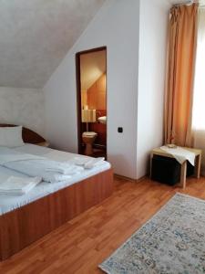 a bedroom with a large bed and a mirror at Pensiunea Cold Mountains in Râşnov