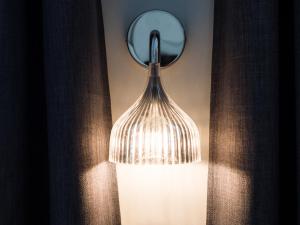 a lamp with a mirror on a wall at Hyper centre chambre au calme in Lille