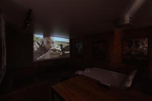 a room with a tv with a man on the screen at Квартира студия в центре Cinema in Petropavlovsk