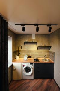a kitchen with a washing machine and a sink at Квартира студия в центре Cinema in Petropavlovsk