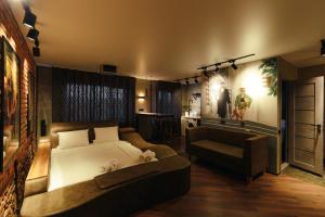 a bedroom with a bed and a couch and a table at Квартира студия в центре Cinema in Petropavlovsk