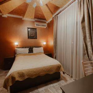 1 dormitorio pequeño con cama y techo en Galeon Hotel en Bishkek