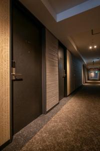 an empty corridor of a building with doors and carpet at Hotel Kanazawa in Kanazawa