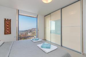 um quarto com uma cama e uma grande janela em Panorama Seaview Kolomban em Ankaran