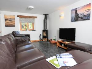 a living room with a couch and a flat screen tv at Cowslip Cottage in South Pool