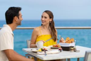 
a man and woman sitting at a table with food at Cozumel Palace-All Inclusive in Cozumel
