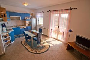 a kitchen with blue cabinets and a table with chairs at Apartments Marinić in Primošten