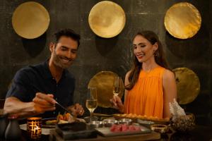 mężczyzna i kobieta stojący przed stołem z jedzeniem w obiekcie Cozumel Palace-All Inclusive w mieście Cozumel