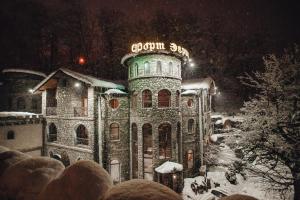 a building with a neon sign on it in the snow at Fort Evrika in Estosadok